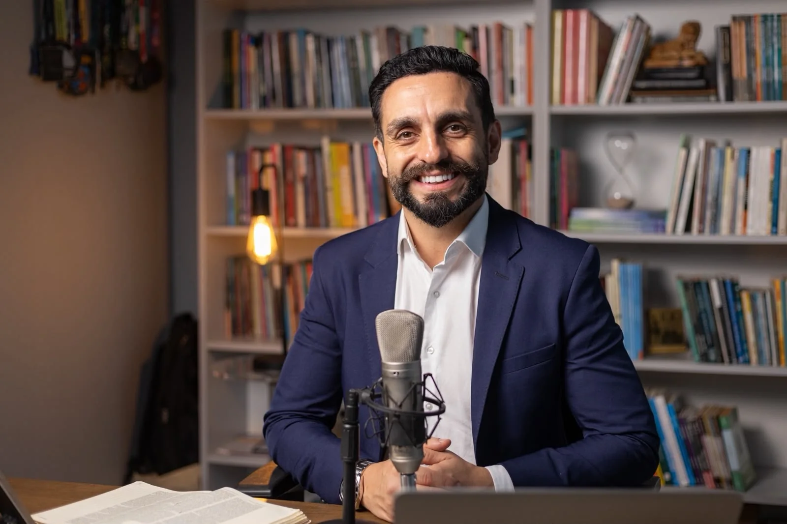 Pastor Rafael Coelho em seu estúdio, sorrindo diante do microfone